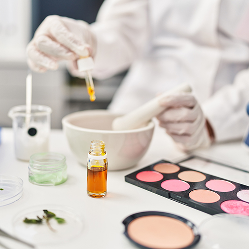 Young hispanic woman scientist making makeup working at laboratory